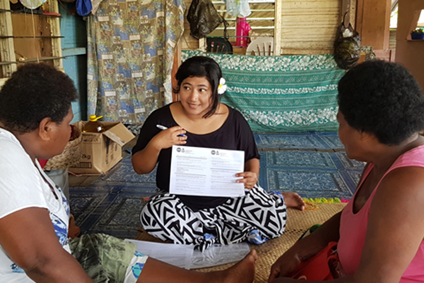 A woman explaining something to two people from different nationality
